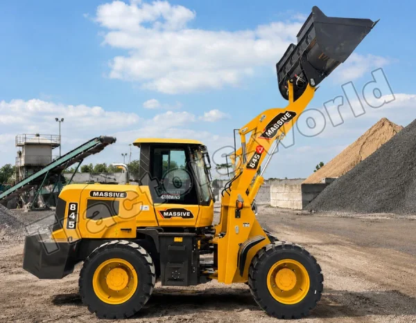 Yellow front-end loader at a construction site raising its bucket filled with earth or gravel in the air